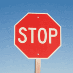 Stop sign against a clear blue sky symbolizing stopping human trafficking and online tracking.
